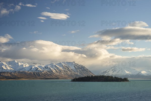 Island in Lake Tekapo in front of a mountain range