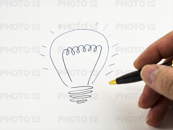 Hand drawing a light bulb