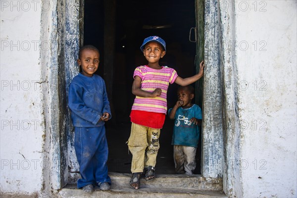 Young children standing in a door frame