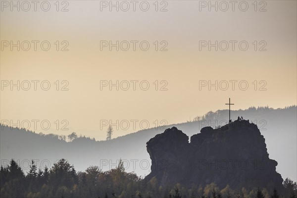 Bruchhauser Steine rocks with a group of visitors at the summit cross