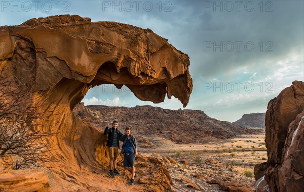 Two teenagers standing on a rock formation