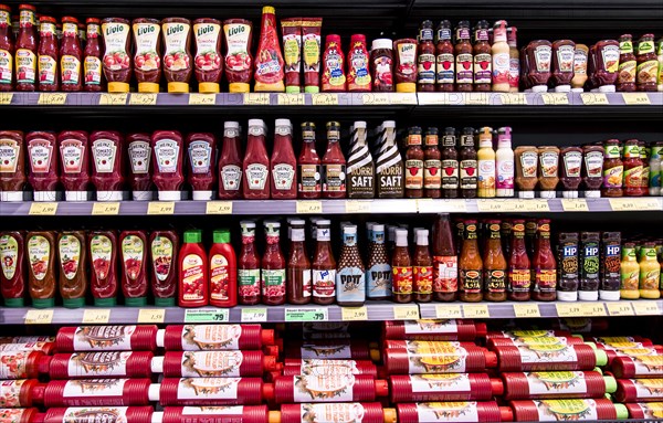 Shelf with various ketchups and sauces