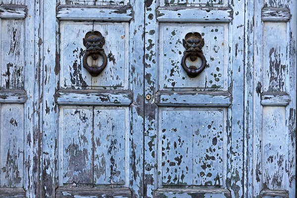 Detail of old blue gate and door knockers