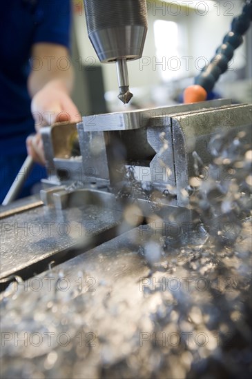 Countersink drilling with a drill press during the apprenticeship for a mechatronics engineer