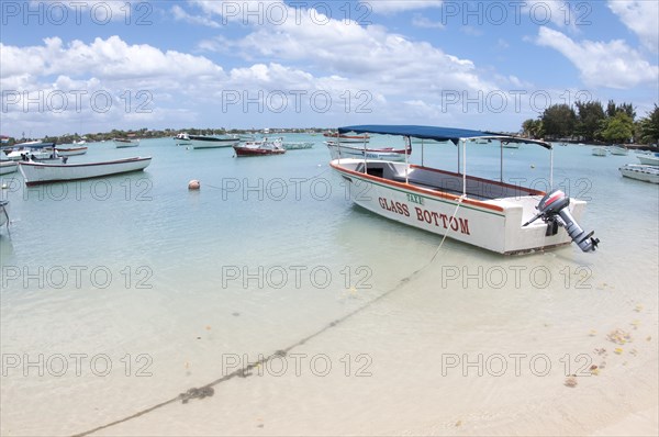 Glass bottom tourist boat moored beside sandy beach