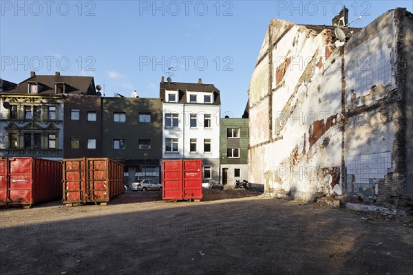 Containers for construction debris in front of houses marked for demolition