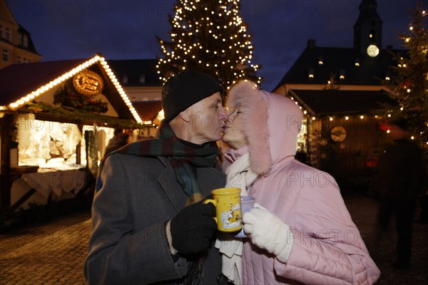 An elderly couple kissing at the Christmas market in Annaberg-Buchholz