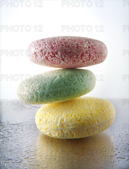 Three bars of scented soap piled on aluminium with water droplets