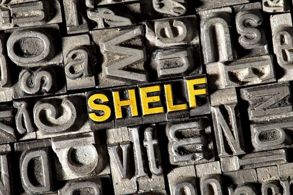Old lead letters forming the word 'SHELF'