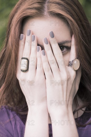 Young woman covering her face with her hands