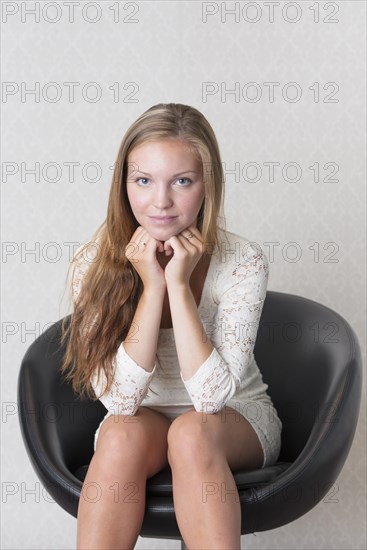 Young woman sitting in a vintage chair