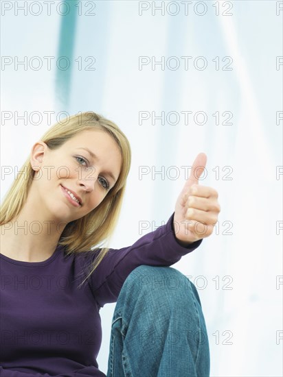 Young woman making a thumbs up gesture