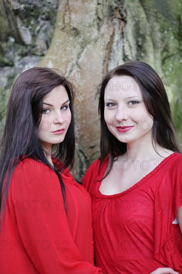 Two sisters in front of an old tree