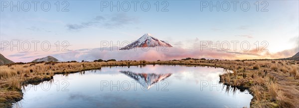 Water reflection in Pouakai Tarn Mountain Lake at sunset