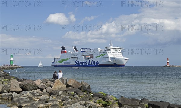 Baltic Sea ferry passes pier light at the entrance to Unterwarnow