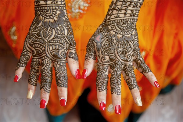 Mehendi tatooed hand of Indian bride on her wedding eve