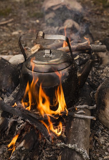 Large sooty coffee kettle on campfire