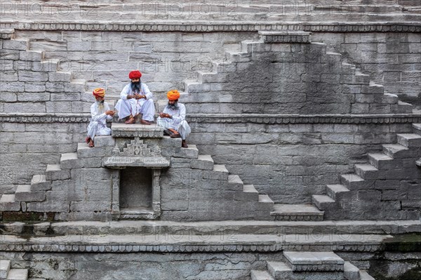 Three men playing cards at the stepwell Toorji Ka Jhalra