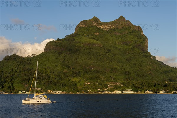 Catamaran in the lagoon off extinct volcano Mont Otemanu