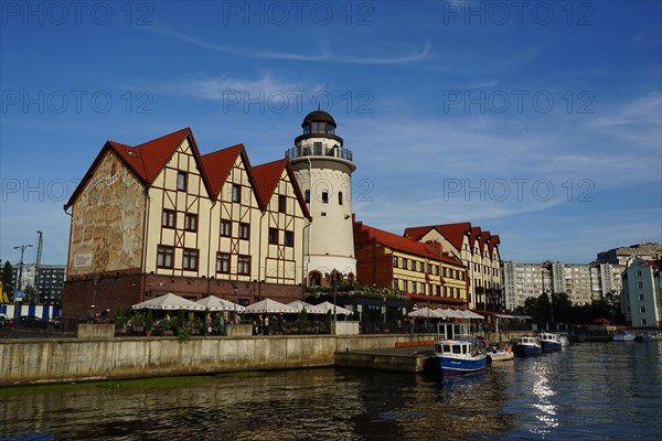 Row of houses in the quarter Fischdorf with historical lighthouse at the river Pregel