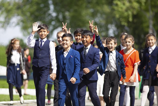 Happy students in evening dress on the university boulevard