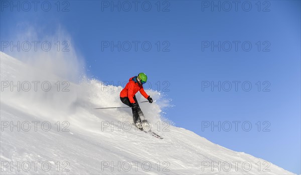 Skier descending steep slope