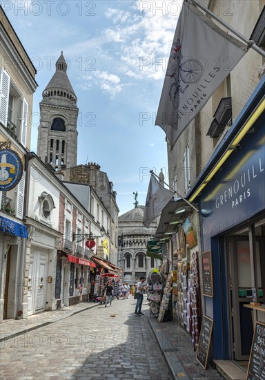 Street with shops in Montmartre overlooking the dome of the Sacre-Coeur Basilica