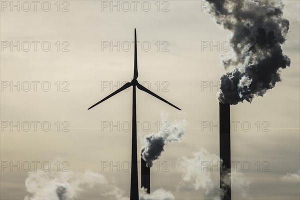 Wind turbine and smoking chimneys at the Uniper coal-fired power plant Scholven