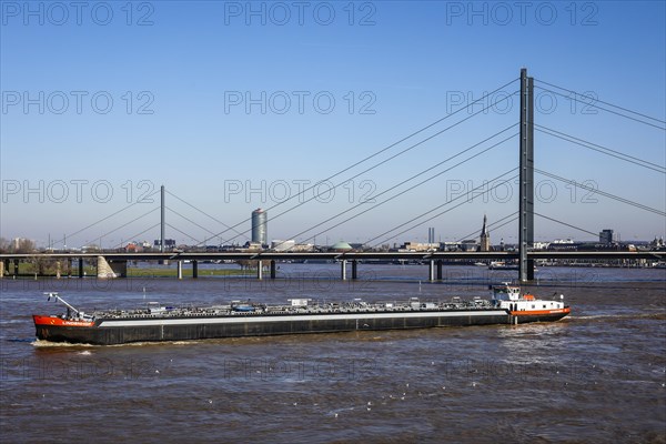 Freighters navigating at high water on the Rhine under the Rheinkniebruecke