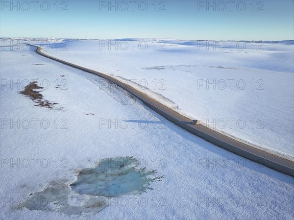 Lonely road to the North Cape in snow covered arctic landscape with motorhome