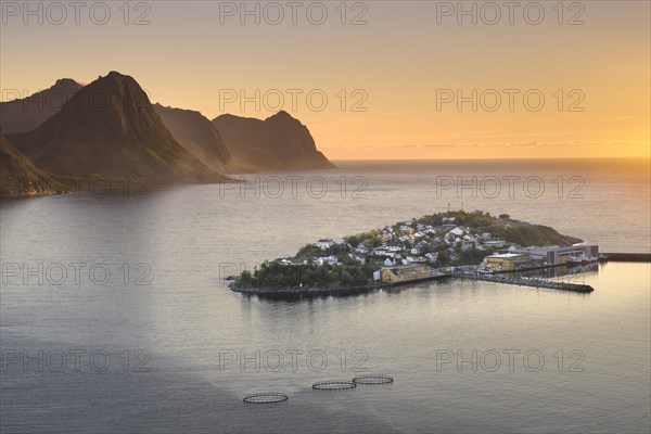 Island with place Husoy in the fjord at low sun with atmospheric light