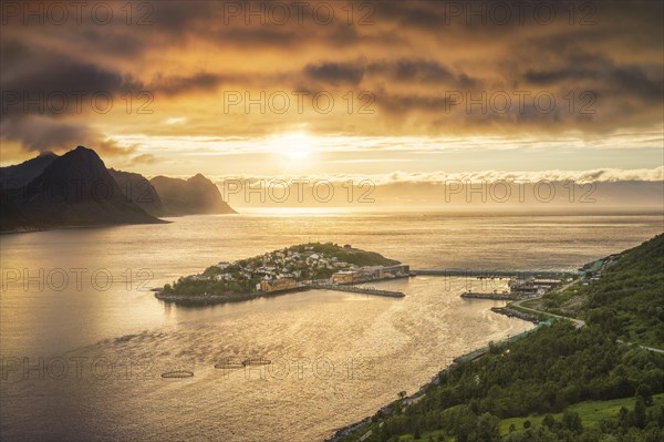 Island with place Husoy in the fjord at low sun with atmospheric light