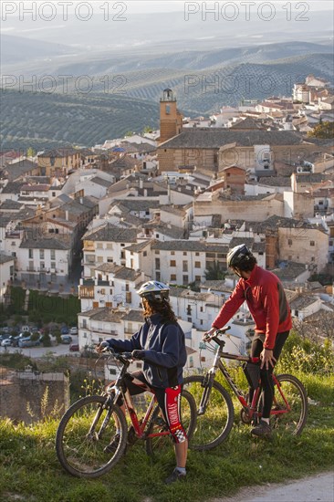 Two mountain bikers observe the village of Cazorla