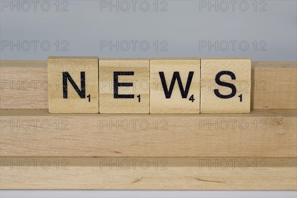 Letter blocks on a wooden bar form the word News