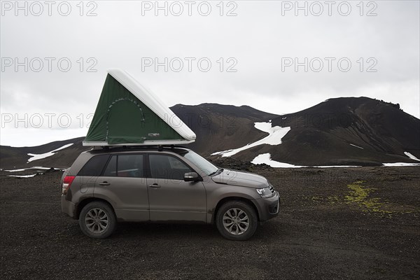 Off-road vehicle with roof tent in the mountains