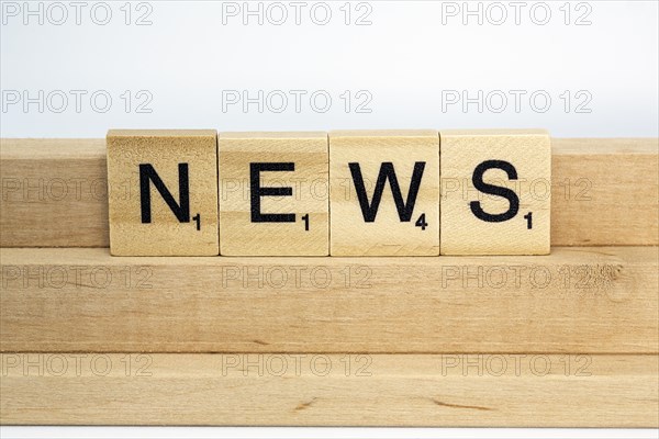 Letter blocks on a wooden bar form the word News