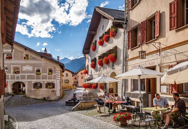 Village street with restaurant terrace and typical houses