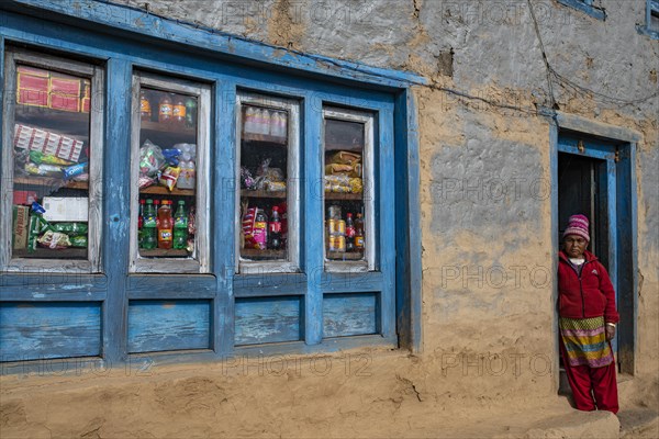 A local woman standing in the doorway of her shop