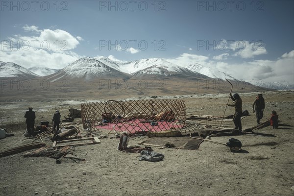 Four men dismantling a yurt