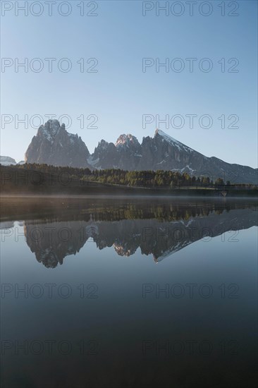 Sassolungo and Plattkofel are reflected in the small lake