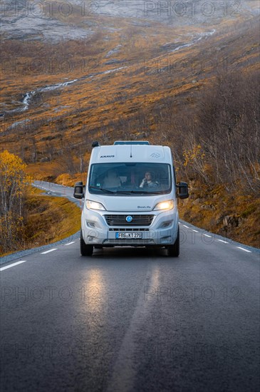 Campervan on a road with autumnal vegetation