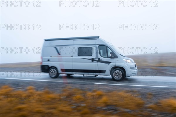 Campervan in fast drive on a road near the North Cape