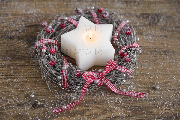 Natural advent decoration with wreath and star shaped candle
