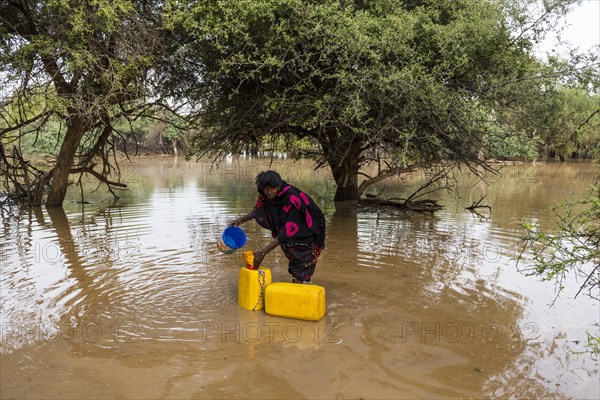 Woman fetches water in canisters