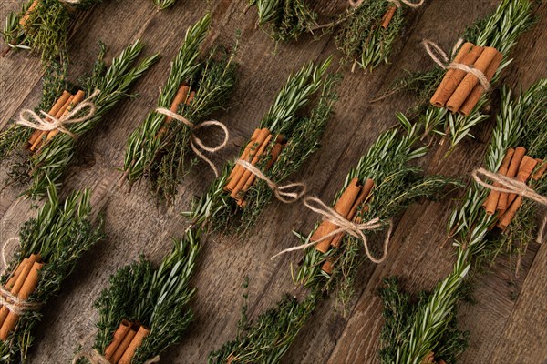 Cinnamon sticks tied together with rosemary and thyme