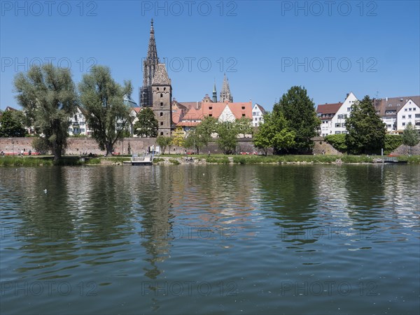 Ulm Cathedral and buildings on the banks of the Danube with water reflection