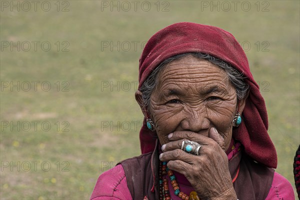 Portrait of an elderly woman with turquoise earring and finger ring