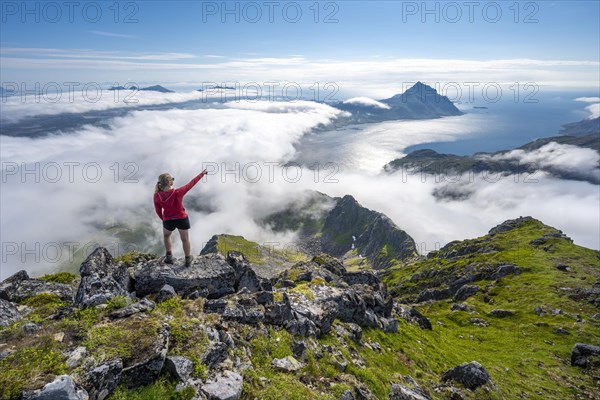 Hiker looking over mountain landscape in clouds