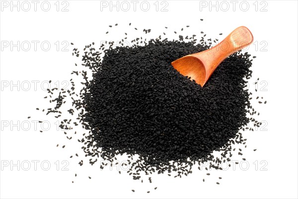 Nigella seeds with a wooden spoon against a white background