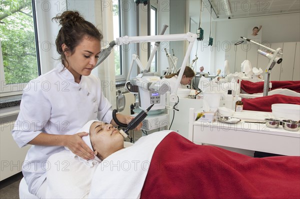 Application of the white face pack with moisture and vitamins in connection with the brush grinder for peeling the skin in practical lessons. Training as a beautician at the vocational school